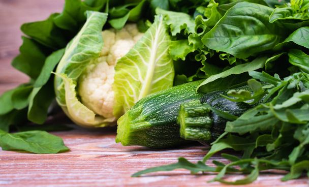 Variety of green vegetables on a wooden background. Healthy food concept. Close-up. Selective focus. - Photo, image