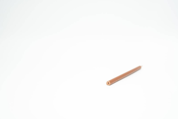 Brown wooden colored pencil on a white background with end part in focus - Foto, imagen