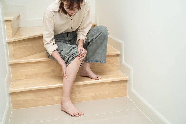 Asijské dáma žena dotknout a cítit bolest její koleno na schodech doma, zdravé lékařské pojetí. - Fotografie, Obrázek
