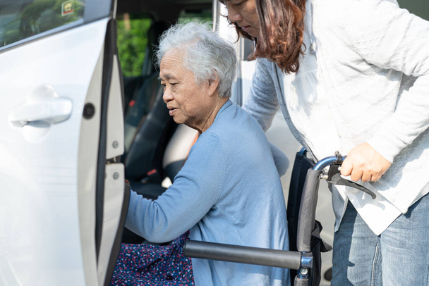 Азиатская пожилая или пожилая старуха пациентка, сидя на инвалидной коляске подготовить добраться до ее автомобиля, здоровый сильный медицинский концепт. - Фото, изображение