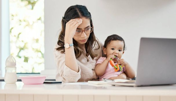 Jeder Tag ist anders mit seinen eigenen Herausforderungen und Segnungen. eine gestresste Frau sitzt mit ihrem Laptop und ihrem Baby auf dem Schoß - Foto, Bild