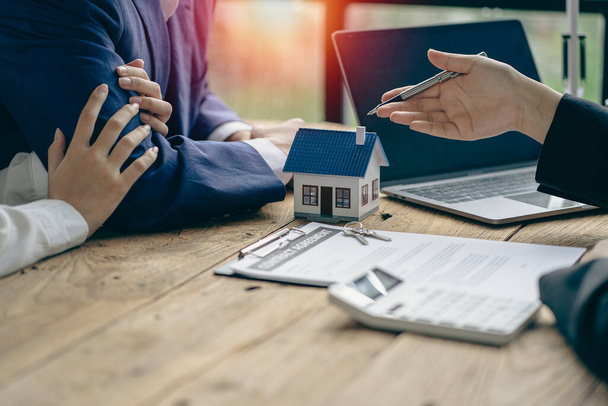 Immobilienmakler sprechen mit neuen Hauskäufern und bieten gute Zinssätze und berechnen Kunden für Hypothekenfinanzierungen, um ihnen bei der Entscheidung für Immobilienideen mit Versicherungen zu helfen. - Foto, Bild