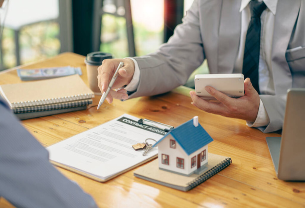 Realitní makléři mluvit s novými kupci domů a nabízejí dobré úrokové sazby a výpočet klientů na hypoteční financování, které jim pomohou rozhodnout o nápadech nemovitostí s pojištěním. - Fotografie, Obrázek