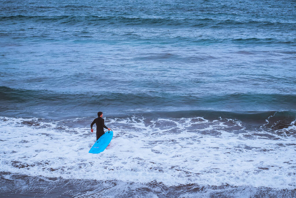 Las Palmas, Ισπανία, 1η Απριλίου 2022 - Surfer going in the ocean - Φωτογραφία, εικόνα