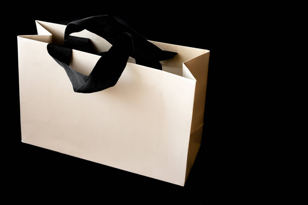 Shopping cardboard bag on black background with space to write. Black friday sale concept. - 写真・画像