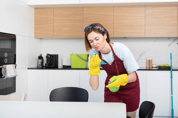 Joven criada limpiando casa y sintiéndose asqueroso después del día de trabajo sucio - Foto, imagen