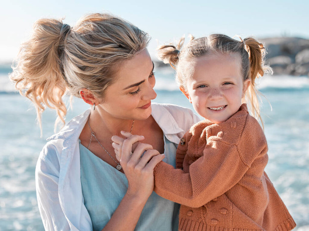 Loving caucasian mother at the beach with her adorable little daughter. Mom and child enjoying beach day during summer vacation. Single mother enjoying quality time with her daughter. - Photo, Image