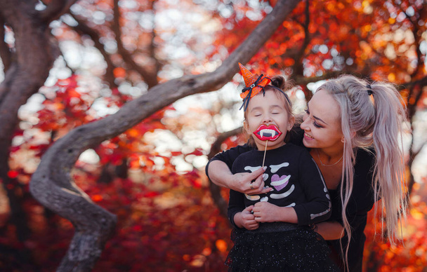 Mother and her child girl playing together. goes trick or treating. Little witch, Kids with jack-o-lantern. Children with candy bucket in fall forest. Happy Halloween. - Фото, зображення
