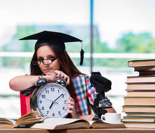 Het jonge meisje voor te bereiden voor examens met grote klok - Foto, afbeelding