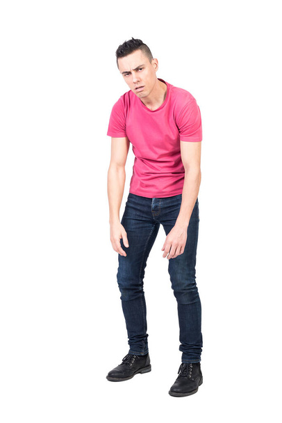 Tired male in casual clothes with round shoulders looking at camera and frowning while taking break against white background - Valokuva, kuva
