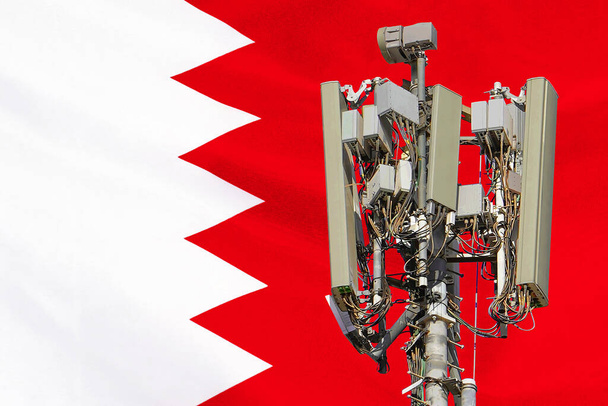 Torre de telecomunicações com uma antena de rede celular 5G agains bandeira do Bahrein. Torre de telecomunicações de comunicação celular 5G. Utilização da tecnologia 5G em torres de telecomunicações no Bahrein - Foto, Imagem