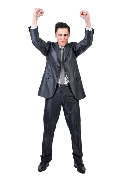 Full body of positive male in formal suit raising clenched fists and looking at camera while celebrating victory isolated on white background in studio - Photo, image