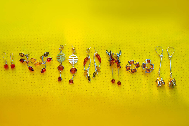 Sterling silver earrings on yellow background - Foto, Imagem