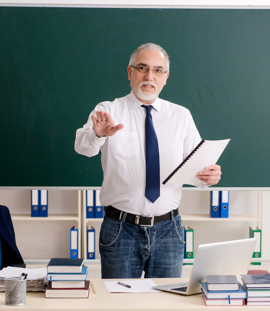 The aged male teacher in front of chalkboard - Photo, Image