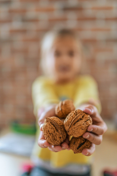 маленька дівчинка з волоськими горіхами
 - Фото, зображення