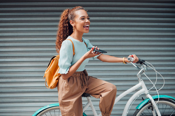 Bike, woman and with phone in city with bicycle talk while outdoor in summer with fresh, edgy and trendy look. Eco friendly transportation, smile and happy girl have conversation, relax and in street. - Photo, image