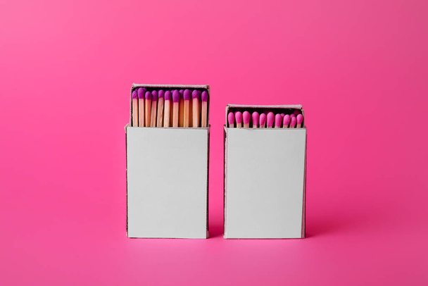 Boxes with new matches on pink background - Foto, imagen