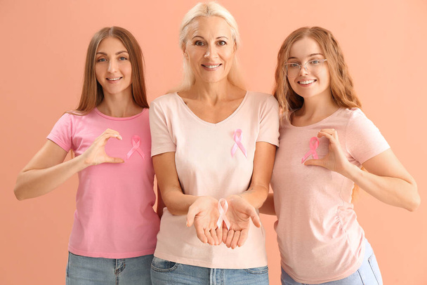 Beautiful women with pink awareness ribbons on color background. Breast cancer concept - Foto, Imagem
