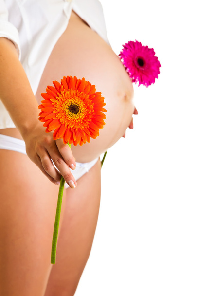 Pregnant woman holding gerbera flower isolated on white - Fotoğraf, Görsel