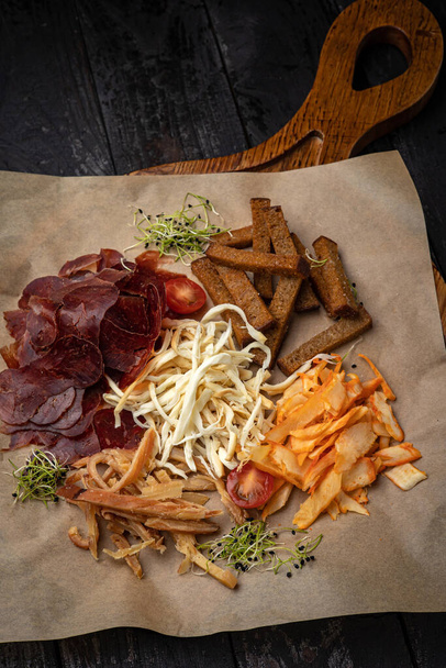croutons, cheeses, smoked meat on a  wooden table - Foto, Bild