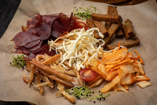 croutons, cheeses, smoked meat on a  wooden table - Φωτογραφία, εικόνα