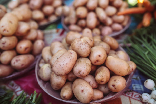 Closeup of fresh organic yellow potatoes on counter of farm market for sale. Rich harvest concept. Healthy organic product.. - Photo, Image