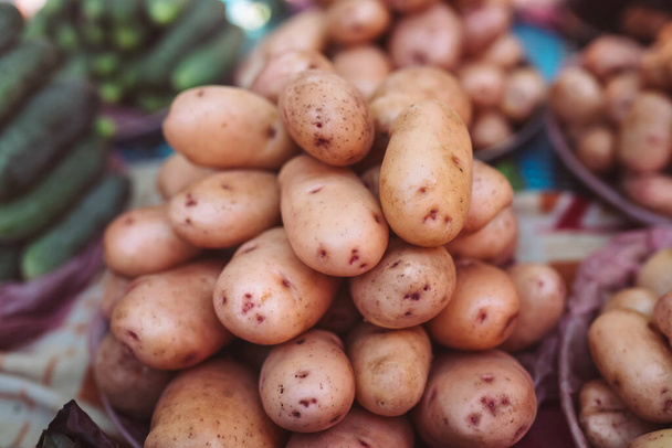 Крупный план свежей органической желтой картошки на прилавке фермерского рынка на продажу. Концепция богатого урожая. Здоровый органический продукт.. - Фото, изображение