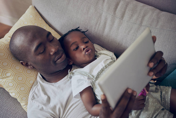 Relajarse con papá. un padre y una hija usando una tableta digital juntos en casa - Foto, Imagen