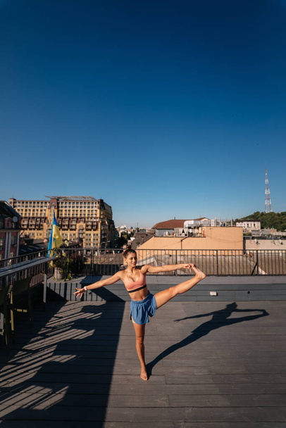 Young woman practicing yoga on the roof - Foto, Bild