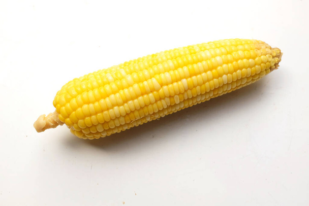 een van gekookte heerlijke rijpe zoete gele maïs (Zea mays L.) isoleren op een witte achtergrond - Foto, afbeelding