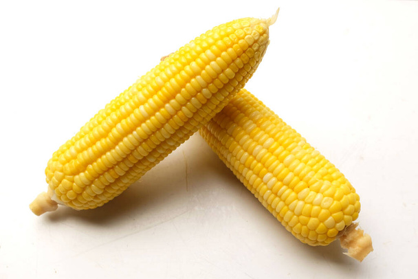 Куча вареных вкусных спелых сладких желтых кукуруз (Zea mays L.) изолировать на белом фоне - Фото, изображение