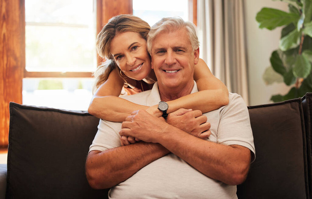 Happy senior couple, hug and relax for love, care and bonding time with smile at home on living room sofa. Portrait of elderly man and woman in relationship happiness hugging and relaxing on couch. - Photo, Image