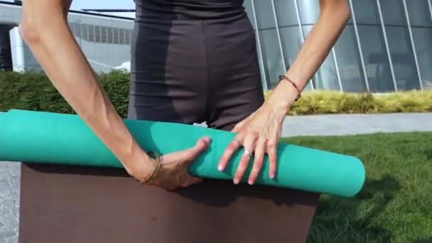 előkészíti a szőnyeget jóga meditációs gyakorlatok a szabadban a városközpontban park - elleni küzdelem a nyüzsgés és a városi élet fizikai és szellemi testmozgás - Milánó életmód sport tevékenységek - Felvétel, videó