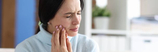 Young woman with severe toothache at home. Sudden pain in tooth concept - 写真・画像