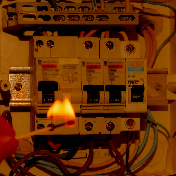 ηλεκτρικό διακόπτη και αναμμένο σπίρτο, υπέρταση ρεύματος - Φωτογραφία, εικόνα