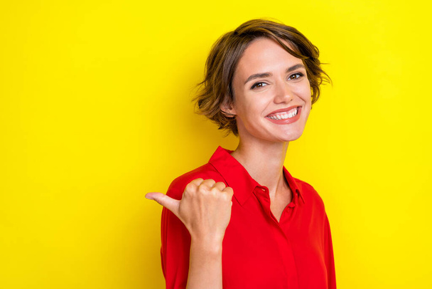 Portrait of gorgeous nice lovely positive girl with bob hairdo dressed red shirt directing empty space isolated on yellow color background. - Φωτογραφία, εικόνα