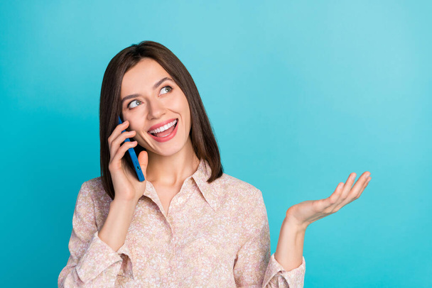 Close up photo of positive pretty lady stylish blouse interested look up empty space speak telephone app isolated on cyan color background. - Фото, зображення