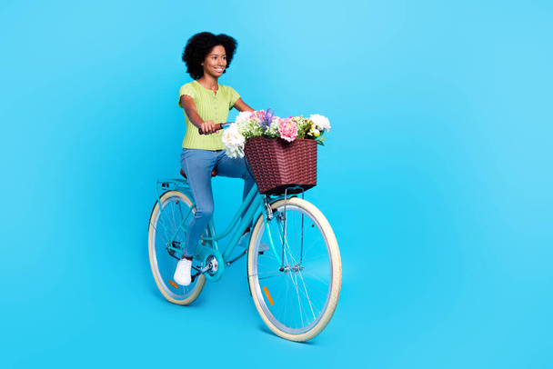 Full body size photo of little cute teenager girl nice outfit riding retro bicycle busket with fresh flowers beautiful weekend isolated on bright blue color background. - Foto, afbeelding