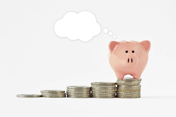Piggy bank com bolha cômica em branco sobre levantar pilhas de moedas - Conceito de economizar dinheiro - Foto, Imagem