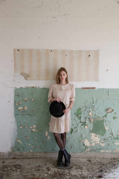 Női modell fotók sorozata bézs ruhában az elhagyatott romos épületben - Fotó, kép