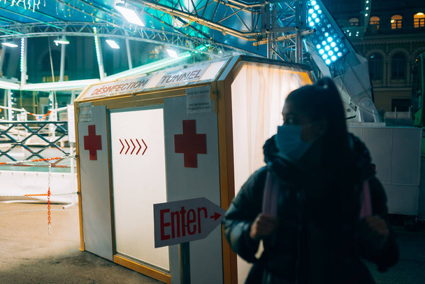 Young beautiful woman in a medic mask is staying at a disinfection tunnel - Foto, Imagem