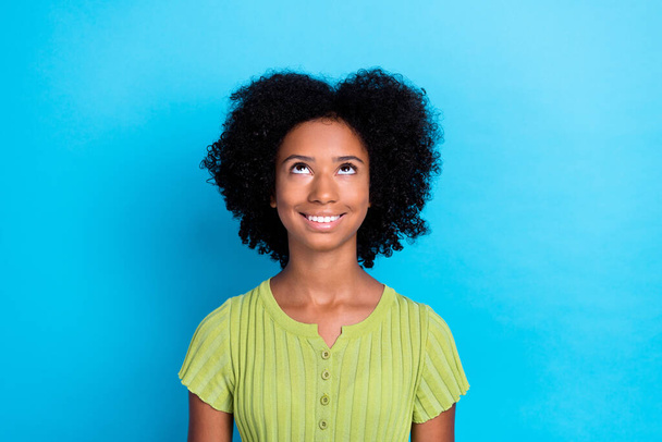 Portrait of good mood nice girl with curly hairstyle wear green t-shirt look empty space isolated on blue color background. - Fotografie, Obrázek