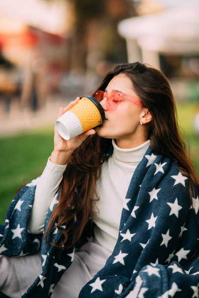 retrato de uma jovem mulher atraente no parque com um copo de papel de café. Descanse no parque - Foto, Imagem