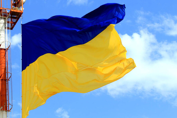 Σημαία της Ουκρανίας κυματίζει στον γαλάζιο ουρανό. Μεγάλη κίτρινη μπλε ουκρανική εθνική σημαία, Κίεβο Ουκρανία. Υπερασπιστής, Ανεξαρτησία, Ημέρα Συντάγματος - Φωτογραφία, εικόνα