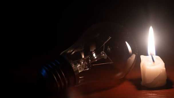 light bulb and candle on black background - Photo, Image