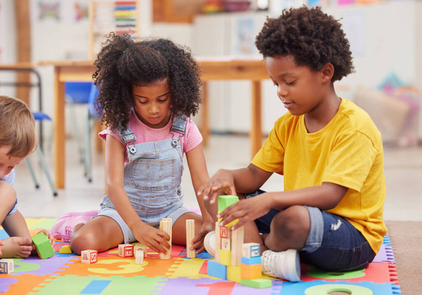 Ein Kind, das mitspielt, steigert seine Fantasie. Vorschulkinder spielen gemeinsam in einer Klasse - Foto, Bild