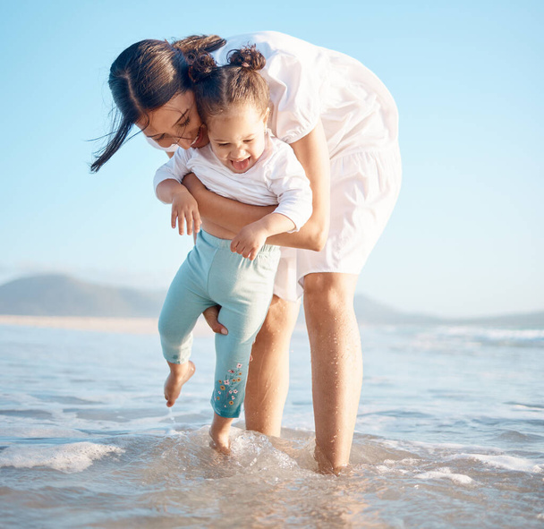 She loves getting her feet wet. a young woman at the beach with her adorable daughter - Фото, изображение