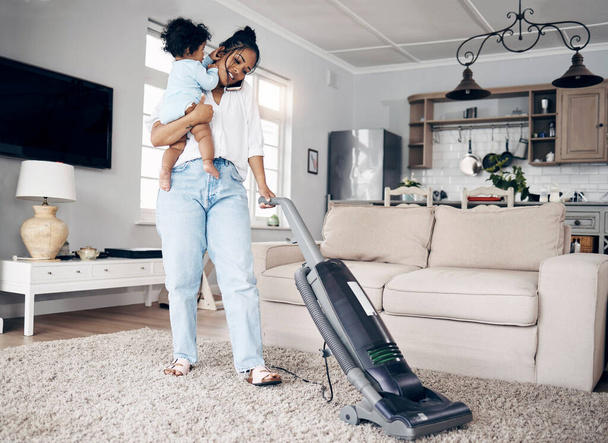 Посмотри, как она уходит. молодая мать с помощью мобильного телефона, выполняя домашнюю работу и держа своего ребенка дома - Фото, изображение