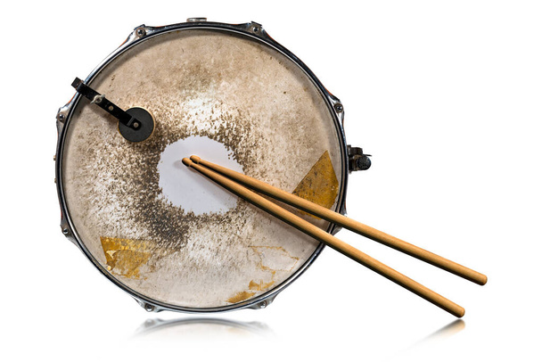 Close-up van twee houten drumstokken en een oude metalen snaredrum, geïsoleerd op witte achtergrond, fotografie. Percussie-instrument. - Foto, afbeelding