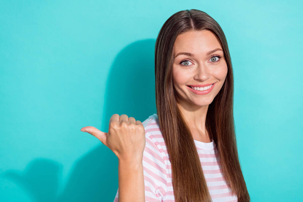 Photo of positive satisfied lovely girl straight hairdo dressed striped t-shirt directing empty space isolated on teal color background. - Φωτογραφία, εικόνα